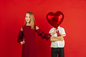 Image showing Valentine\'s day celebration, happy caucasian kids isolated on red background