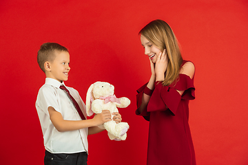 Image showing Valentine\'s day celebration, happy caucasian kids isolated on red background