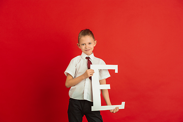 Image showing Valentine\'s day celebration, happy caucasian boy holding letter on red background