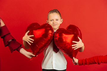 Image showing Valentine\'s day celebration, happy caucasian boy isolated on red background