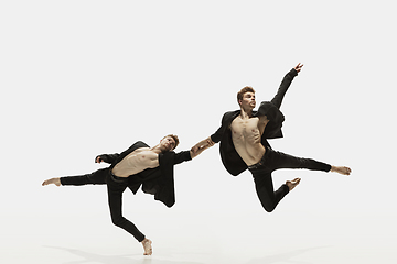 Image showing Man in casual style clothes jumping and dancing isolated on white background. Art, motion, action, flexibility, inspiration concept. Flexible caucasian ballet dancer.