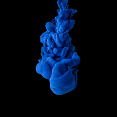 Image showing Explosion of colored, fluid and neoned liquids on black studio background with copyspace