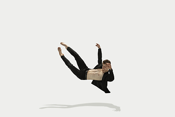 Image showing Man in casual style clothes jumping and dancing isolated on white background. Art, motion, action, flexibility, inspiration concept. Flexible caucasian ballet dancer.