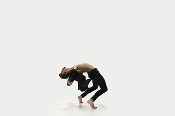 Image showing Man in casual style clothes jumping and dancing isolated on white background. Art, motion, action, flexibility, inspiration concept. Flexible caucasian ballet dancer.