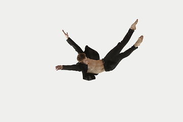 Image showing Man in casual style clothes jumping and dancing isolated on white background. Art, motion, action, flexibility, inspiration concept. Flexible caucasian ballet dancer.