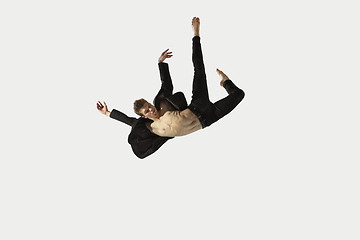 Image showing Man in casual style clothes jumping and dancing isolated on white background. Art, motion, action, flexibility, inspiration concept. Flexible caucasian ballet dancer.