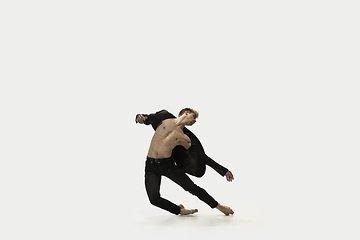 Image showing Man in casual style clothes jumping and dancing isolated on white background. Art, motion, action, flexibility, inspiration concept. Flexible caucasian ballet dancer.