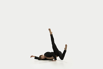 Image showing Man in casual style clothes jumping and dancing isolated on white background. Art, motion, action, flexibility, inspiration concept. Flexible caucasian ballet dancer.