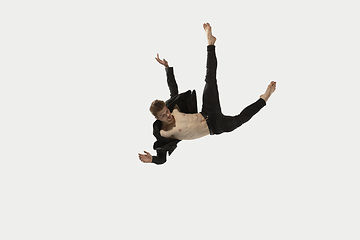 Image showing Man in casual style clothes jumping and dancing isolated on white background. Art, motion, action, flexibility, inspiration concept. Flexible caucasian ballet dancer.