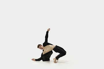 Image showing Man in casual style clothes jumping and dancing isolated on white background. Art, motion, action, flexibility, inspiration concept. Flexible caucasian ballet dancer.