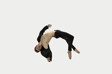 Image showing Man in casual style clothes jumping and dancing isolated on white background. Art, motion, action, flexibility, inspiration concept. Flexible caucasian ballet dancer.