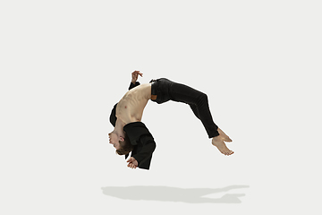 Image showing Man in casual style clothes jumping and dancing isolated on white background. Art, motion, action, flexibility, inspiration concept. Flexible caucasian ballet dancer.