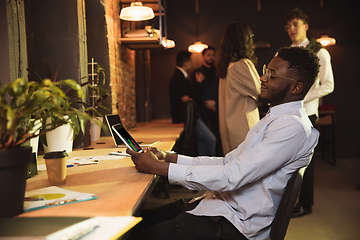 Image showing Colleagues working together in modern office using devices and gadgets during creative meeting