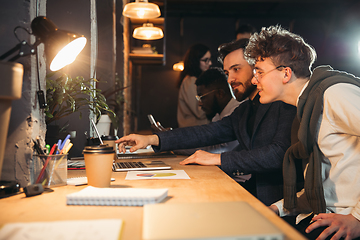 Image showing Colleagues working together in modern office using devices and gadgets during creative meeting