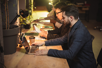 Image showing Colleagues working together in modern office using devices and gadgets during creative meeting