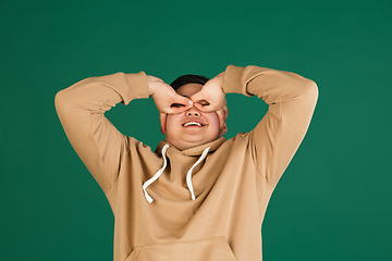 Image showing Asian man\'s portrait isolated over green studio background with copyspace