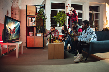 Image showing Group of friends watching TV, sport match together. Emotional fans cheering for favourite team, watching on exciting game. Concept of friendship, leisure activity, emotions