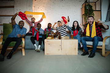 Image showing Group of friends watching TV, sport match together. Emotional fans cheering for favourite team, watching on exciting game. Concept of friendship, leisure activity, emotions