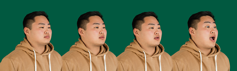 Image showing Evolution of emotions. Asian man\'s portrait isolated over green studio background with copyspace