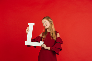 Image showing Valentine\'s day celebration, happy caucasian girl holding letter on red background