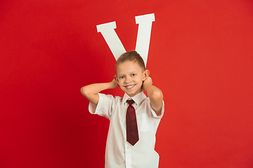 Image showing Valentine\'s day celebration, happy caucasian boy holding letter on red background