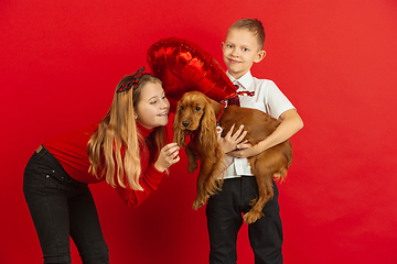 Image showing Valentine\'s day celebration, happy caucasian teens isolated on red background