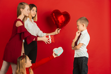 Image showing Valentine\'s day celebration, happy caucasian teens isolated on red background