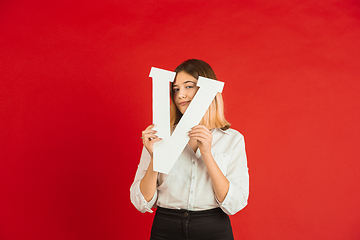 Image showing Valentine\'s day celebration, happy caucasian girl holding letter on red background