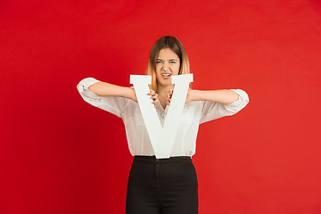 Image showing Valentine\'s day celebration, happy caucasian girl holding letter on red background