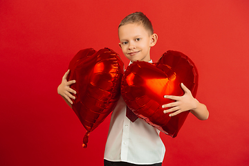 Image showing Valentine\'s day celebration, happy caucasian boy isolated on red background