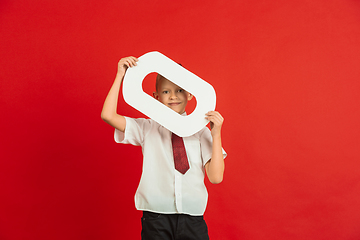 Image showing Valentine\'s day celebration, happy caucasian boy holding letter on red background