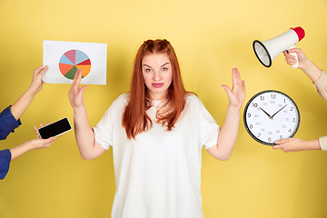 Image showing Caucasian young woman\'s portrait on yellow background, too much tasks