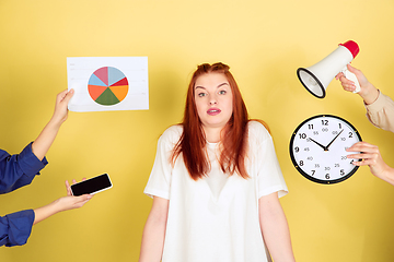 Image showing Caucasian young woman\'s portrait on yellow background, too much tasks