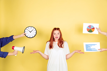 Image showing Caucasian young woman\'s portrait on yellow background, too much tasks