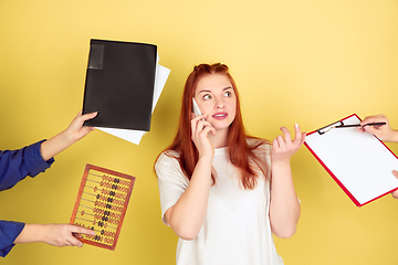 Image showing Caucasian young woman\'s portrait on yellow background, too much tasks