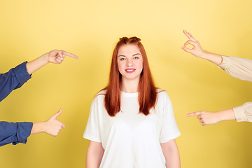 Image showing Caucasian young woman\'s portrait on yellow background, too much tasks