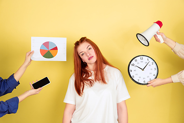 Image showing Caucasian young woman\'s portrait on yellow background, too much tasks