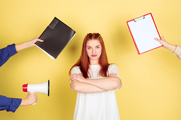 Image showing Caucasian young woman\'s portrait on yellow background, too much tasks