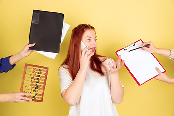 Image showing Caucasian young woman\'s portrait on yellow background, too much tasks