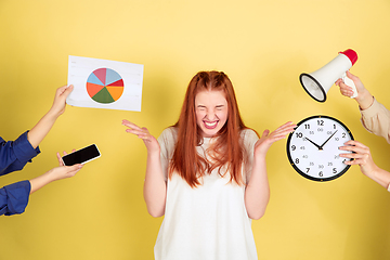 Image showing Caucasian young woman\'s portrait on yellow background, too much tasks