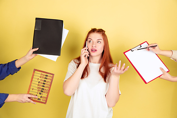 Image showing Caucasian young woman\'s portrait on yellow background, too much tasks