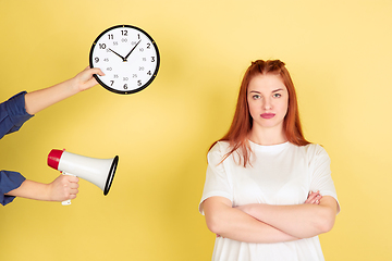 Image showing Caucasian young woman\'s portrait on yellow background, too much tasks