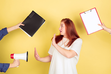 Image showing Caucasian young woman\'s portrait on yellow background, too much tasks