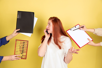 Image showing Caucasian young woman\'s portrait on yellow background, too much tasks