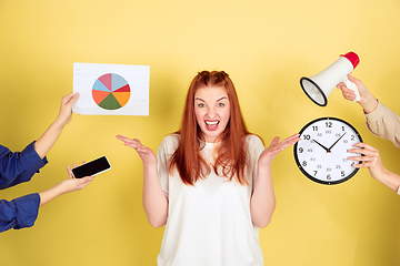 Image showing Caucasian young woman\'s portrait on yellow background, too much tasks