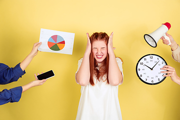 Image showing Caucasian young woman\'s portrait on yellow background, too much tasks