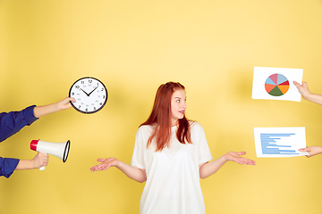 Image showing Caucasian young woman\'s portrait on yellow background, too much tasks