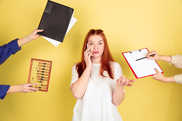 Image showing Caucasian young woman\'s portrait on yellow background, too much tasks