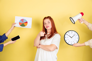 Image showing Caucasian young woman\'s portrait on yellow background, too much tasks