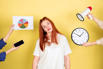 Image showing Caucasian young woman\'s portrait on yellow background, too much tasks